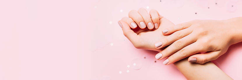 Shellac-Nägel: Zwei Hände mit rosa Shellac-Nägeln nach einer Maniküre.