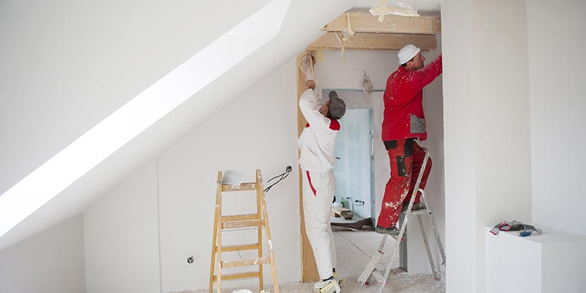 Wohnung streichen: Professionelle Maler streichen eine Wohnung mit Dachschräge.