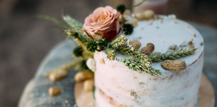 Hochzeitstorte mit Blumen, Getreidehalmen und Erdnüssen als Deko-Idee