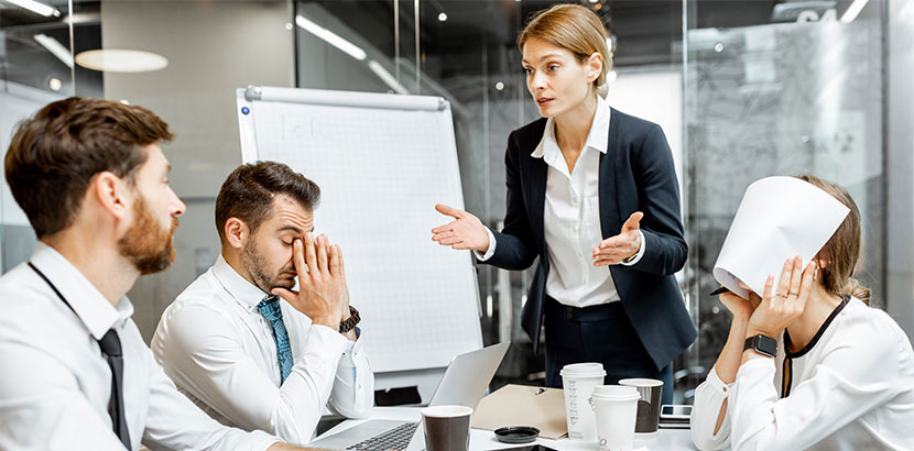 Einige Mitarbeiter streiten in einem Meeting und sind sichtbar gestresst.